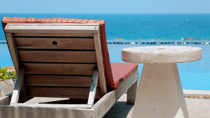 Beach chair by the pool on a sunny day. Concept of relaxation and summer vacation.