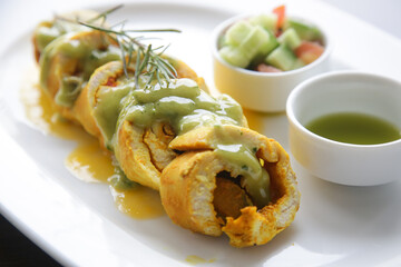 Stuffed chicken rolls served with sauce and vegetables on the resturant table