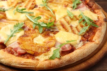 Delicious pineapple pizza with arugula on table, closeup