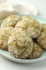 Plate with tasty matcha cookies on white table, closeup