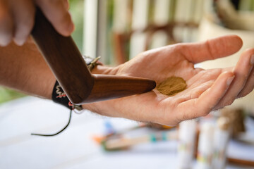 Obraz premium Aplicação do Rapé (Hape) Indígena com o aplicador tepi, medicina da floresta