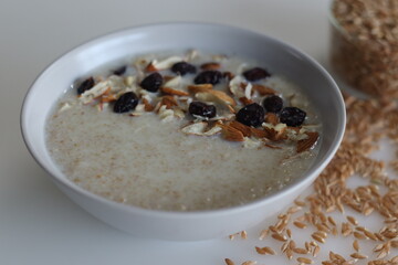 Khapli wheat porridge. Healthy porridge made of broken emmer wheat, simmered in milk and served with sliced almonds and raisins