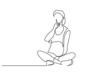 young woman sitting on floor making silence sign with forefinger showing warning