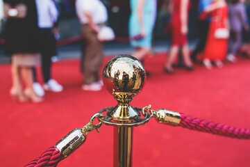 Red carpet with ropes and golden barriers on a luxury party entrance, cinema premiere film festival event award gala ceremony, wealthy rich guests arriving, outdoor decoration elements, summer day