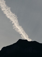 Dispersing vapour trail above the Augstmatthorn summit in late evening