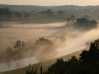Fototapeta premium Sun illuminating early morning mist over the River Wye at Ballingham, Herefordshire