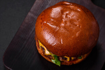 Burger with juicy beef cutlet, cheese, tomatoes, salt, spices and herbs