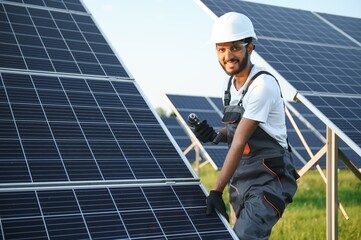 An Indian worker installs solar panels. The concept of renewable energy.