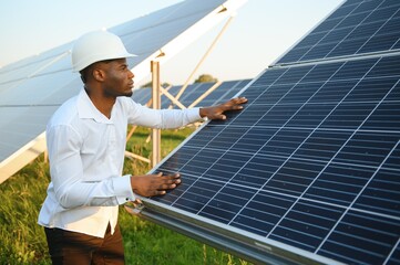 Close up portrait of young handsome African American craftsman a protective helmet. Happy man in...