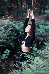 Romantic portrait of a asian woman in a fern in the forest. Art woman natural makeup resting in nature. Green fern thickets