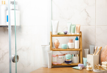 Care cosmetics on the shelf in the bathroom. Cosmetic tube. Cleanser, face and body cream, face roller and gua sha, tonic. Shelf with cosmetics in the interior of the bathroom.Beauty concept. 