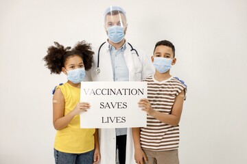 Two multiracial kids with doctor holding a poster that vaccination saved lives