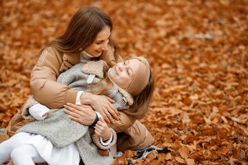 Mother and her daughter hugging in autumn forest