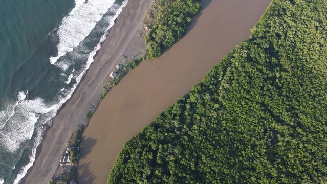El Paredon, a charming coastal surfer village, enjoys sunlight. Rustic huts, black sands and amazing waves. A slice of tropical paradise on the shore of the Pacific Ocean in Guatemala.
