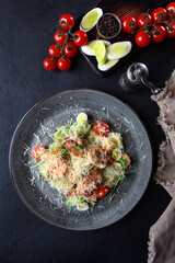 Shrimp salad. Caesar seafood salad with shrimp, parmesan cheese and Caesar dressing on a dark background. Top view.
