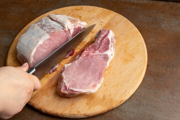 Cut a large piece of pork into portions with a knife