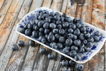 Blueberry in the bowl on the wooden table, Closeup