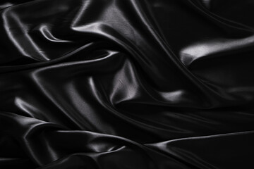 Fototapeta premium Silk fabric, abstract wavy black satin fabric background.