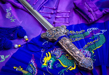 Chinese sword over traditional fan and costume