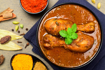 Indian chicken curry leg piece with traditional whole spices