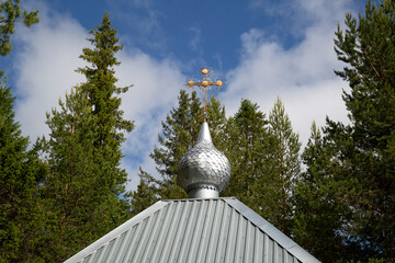 Orthodox cross on the dome of the church against the blue sky.