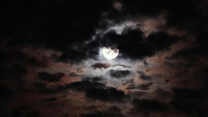 Full moon on a dark cloudy night with clouds flying in front of the moon like in thrillers and horror movies. Dark night sky, black clouds. Real shooting - Powered by Adobe
