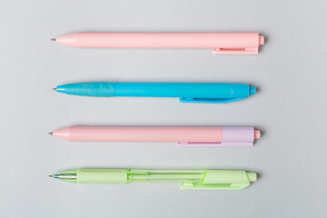 Pastel coloured pens on color backgroung, top view