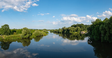 Fototapeta na wymiar Panorama rzeki Odry w tle lekko pochmurna pogoda, błękit nieba zieleń przy brzegu, pora letnia, Odra w odcinku województwa Opolskiego 