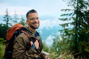 Obraz premium Young happy man hiking in nature and looking at camera.