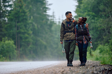Embraced couple of hikers enjoy in walk by road in nature.