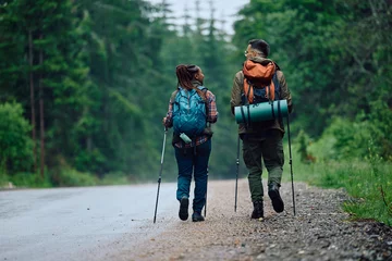 Foto op Plexiglas Kamperen Rear view of backpackers walk by road in nature.