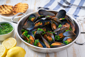 Traditional boiled seafood mussels with herbs and  toasted baguette.