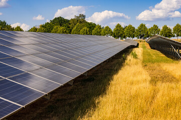 View along many photovoltaic solar panels in a solar park, Germany