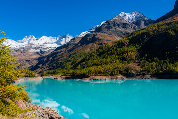 Autumnal landscape of the Lake Place Moulin, an artificial glacial lake with turquoise water in the...