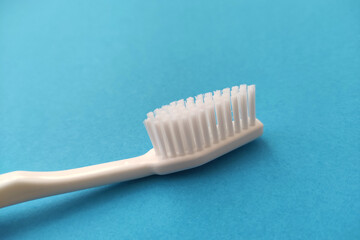 White toothbrush isolated on blue background