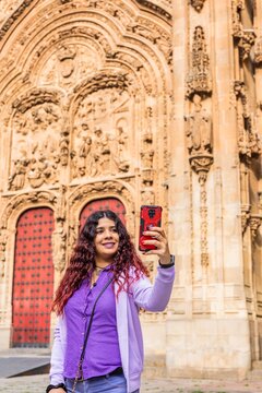 Smartphone technology holiday vacation. Latin American mid-female. Lifestyle selfie in Salamanca.