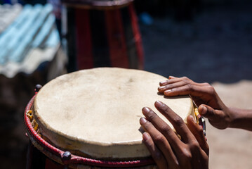 Hands of a musician standing still on a Brazilian atabaque.