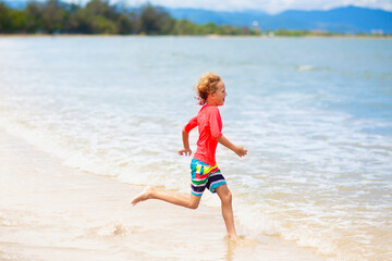 Kids play on tropical beach. Sand and water toy.