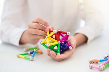 Child playing with magnetic building blocks.
