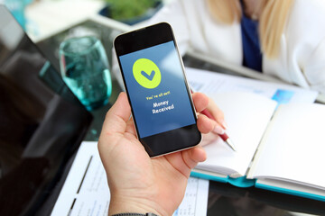 Business persons working  together in the office. Businessman showing a mobile phone with  a statement that payment received.