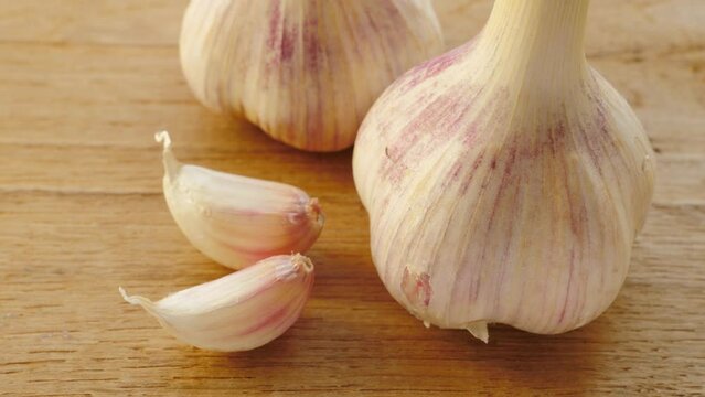 Close up of garlic bulb and clove on wooden rustic board. Healthy eating, aromatic spice.