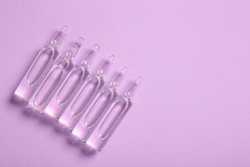 Medical ampules on lilac background