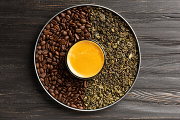 Composition of green tea, coffee beans and coffee in a cup on a dark background top view.