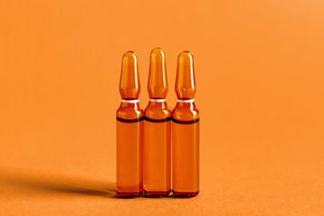 Glass ampules on orange background
