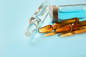 Medical ampules and bottle with medicines on blue background