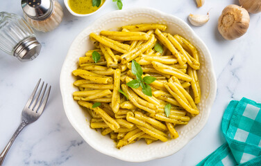 Casarecce pasta with cilantro pesto sauce on a grey background, top view. Delicious vegetarian lunch.