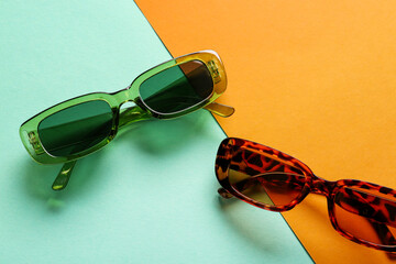 Modern eyeglasses on color background