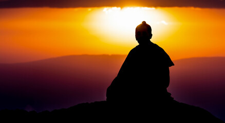 buddhist person meditating on the mountain in a beautiful sunset