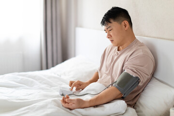 Unhealthy chinese mature man doing morning checkup after waking up