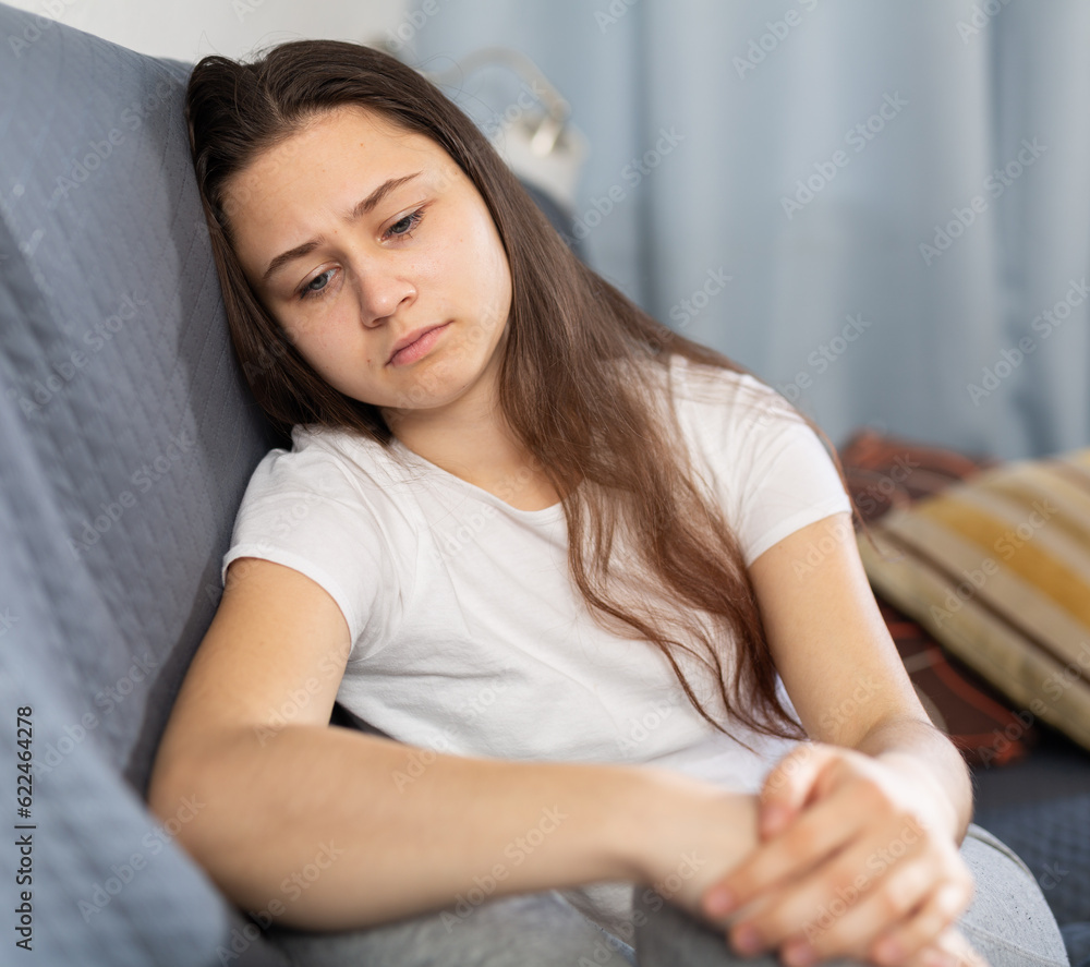 Wall mural woman who crying and thinking about troubles on sofa